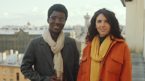 Portrait-of-Smiling-Multiethnic-Man-and-Woman-on-Rooftop-Terrace